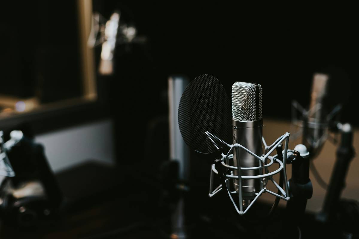 meditation guide cast recording setup with microphone, soundproofing foam, and script notes